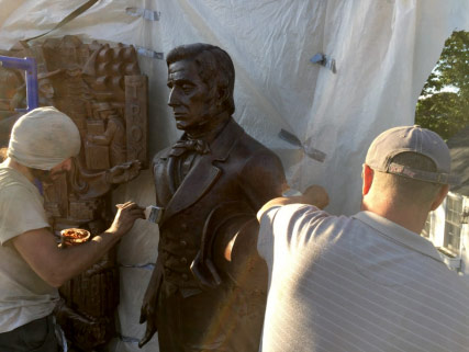 Workers performing statue restoration 2018