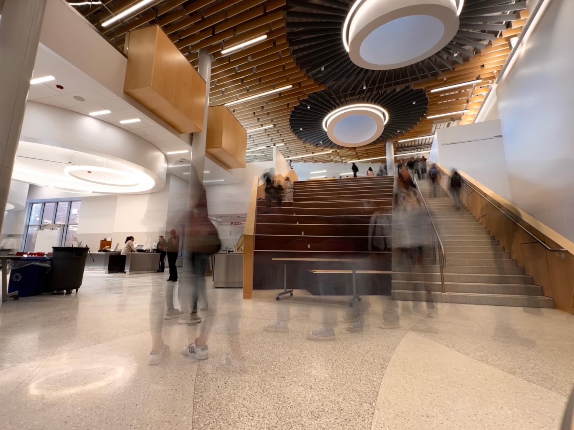 Blurred images of students walking down the stairs of the new Arlington High School