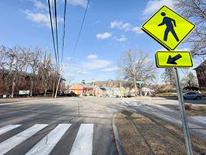 A Yellow Pedestrian Sign by a crosswalk