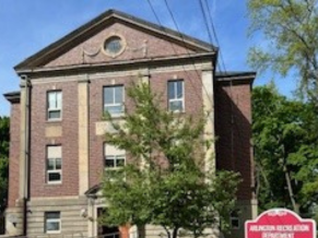 School building with tree in foreground.