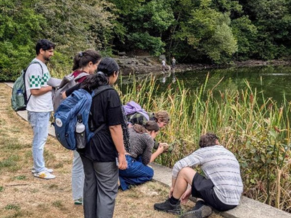 Group of people observing lake.